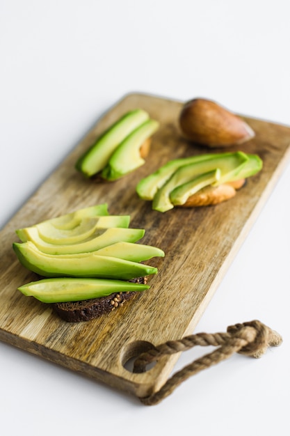 Geschnittene Avocado auf hölzernem Schneidebrett.