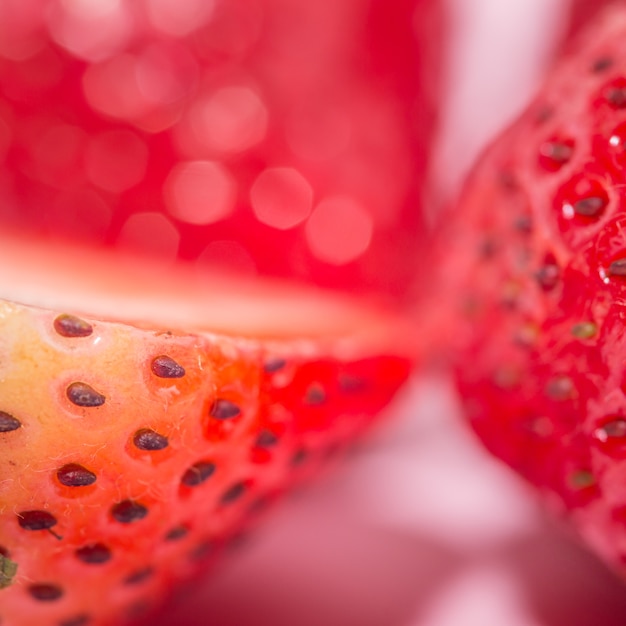 Geschnittene Erdbeerfrucht lokalisiert auf rosa Hintergrund, Pop-Arten-Farbkonzept