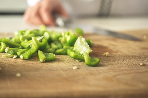 Geschnittene grüne Paprika auf Holzbrett. Gemüsezutat, gesundes Lebensmittelkonzeptfoto kochen