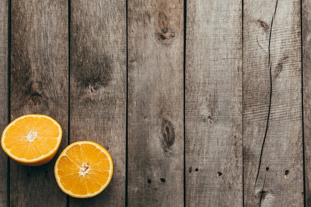 Geschnittene Hälften der Orangenfrucht auf grauem hölzernem Hintergrund. Zellstoff.