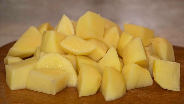 Geschnittene Kartoffeln in der Küche auf einem hölzernen Hintergrund