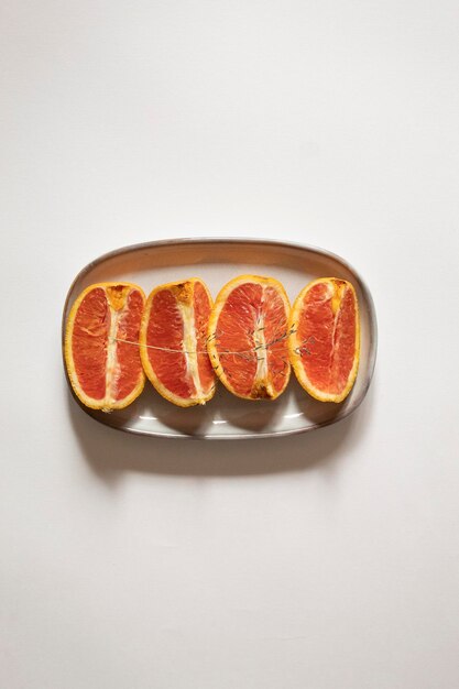 Foto geschnittene orangen auf einem teller auf weißem hintergrund