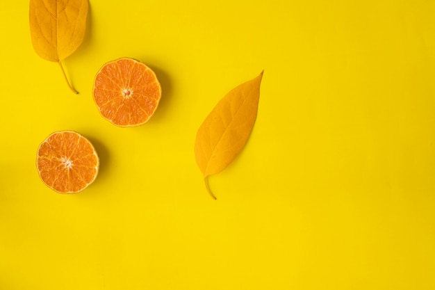 Geschnittene Orangenfrucht auf Gelb, Ansicht von oben.