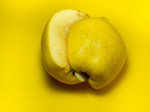 Geschnittene Quitte Saftige Frucht auf gelbem Hintergrund Reifes nützliches Produkt Ernährung bei einer Diät Hintergrund von Fruchthälften geschnittenes Produkt Verdunkelung der geschnittenen Frucht