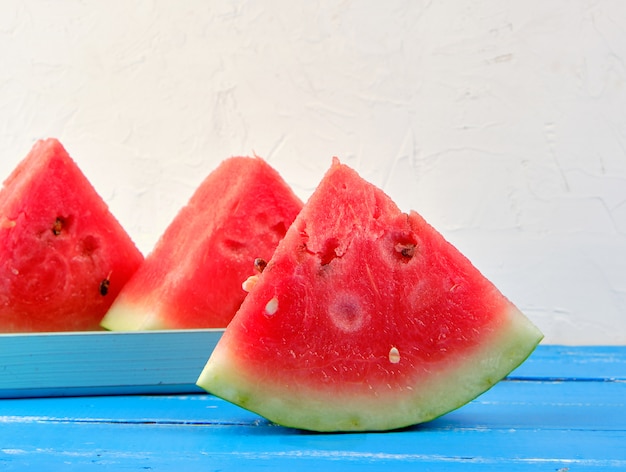 Geschnittene reife rote runde Wassermelone der Dreiecke mit Samen