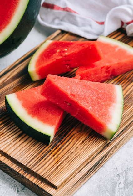 Geschnittene reife Wassermelone auf Holzbrett, Nahaufnahme.