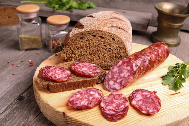 Geschnittene Salami und Brot auf einem Schneidebrett