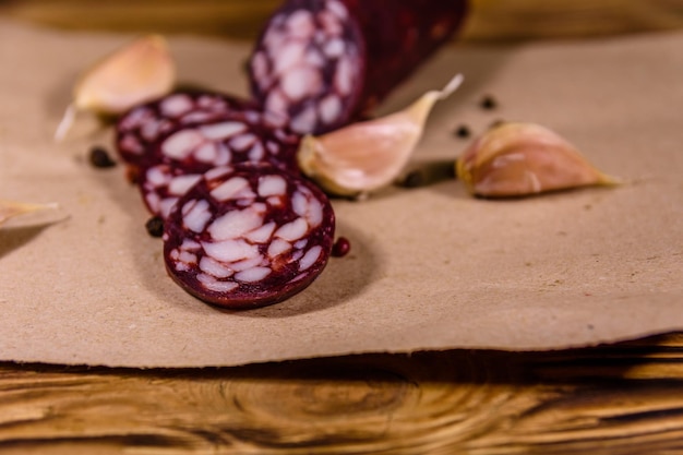 Geschnittene Salamiwurst und Knoblauch auf einem braunen Packpapier