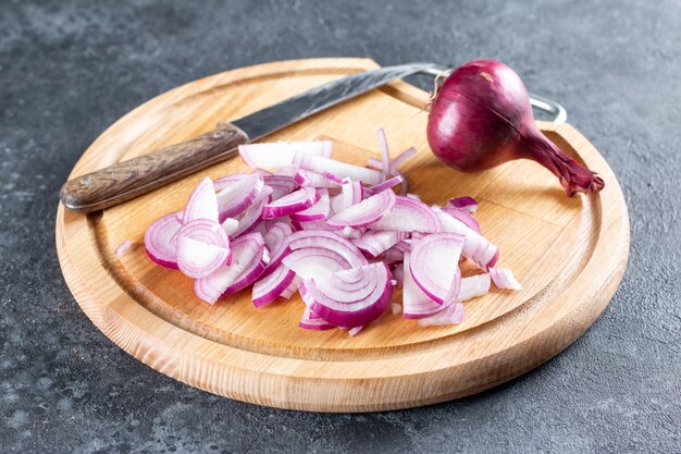 Geschnittene süße Zwiebeln für einen herzhaften Salat mit Paprika, Karotten, Gemüse und Sesam. Schritt für Schritt Rezept. Gesundes Essen