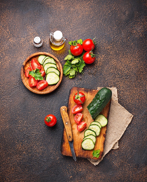 Geschnittene Tomate und Gurke auf Schneidebrett