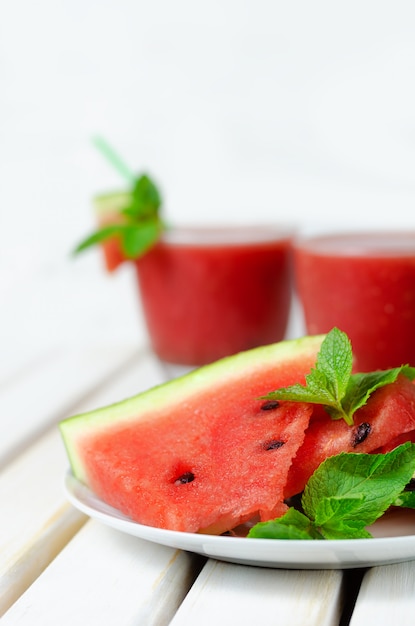 Geschnittene Wassermelone mit Minze auf Weiß