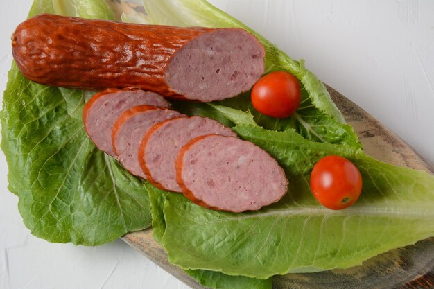 Geschnittene würzige Räucherwurst vom Rind/Schwein. Mit Salatblatt und Cherrytomaten.