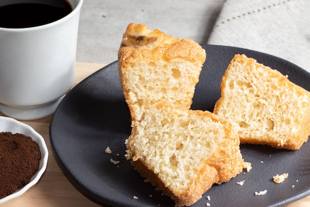 Geschnittener Bananenkuchen, serviert mit schwarzem Kaffee.