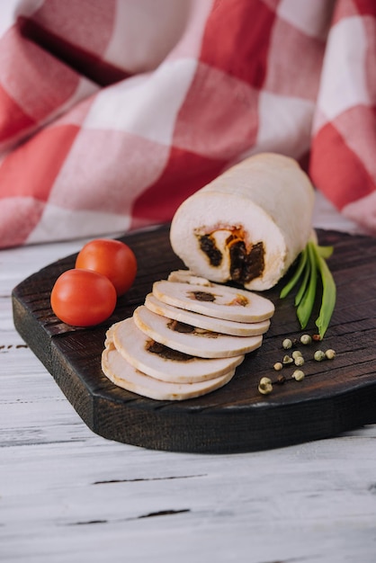 Geschnittener Hackbraten mit Füllung und Tomaten auf einem Schneidebrett