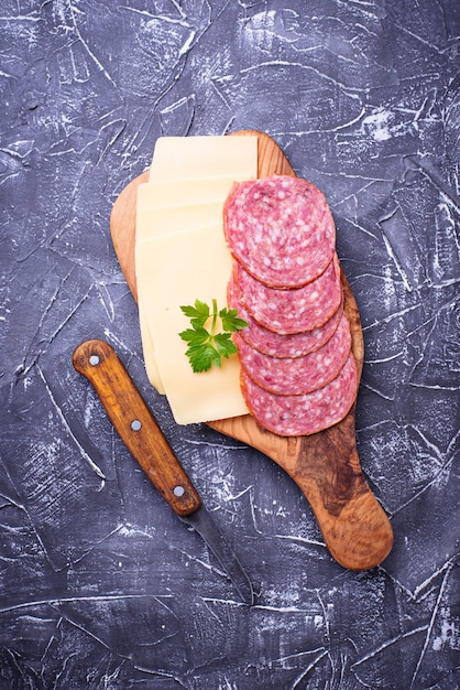 Geschnittener Käse und Salami auf Holzbrett