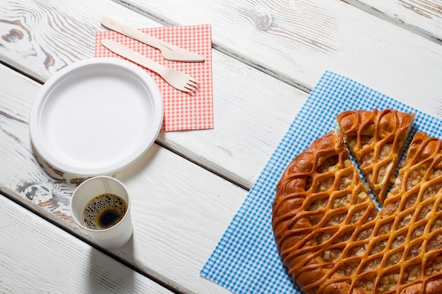 Geschnittener Kuchen, Teller und Besteck. Tasse mit Getränk neben Kuchen. Einfaches Frühstück im Café serviert. Energie und Frische.