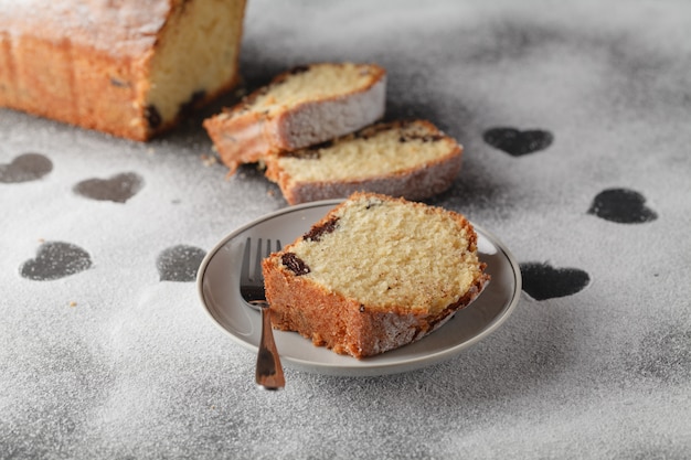 geschnittener Kuchen und Herz des Mehls auf Holzschreibtisch