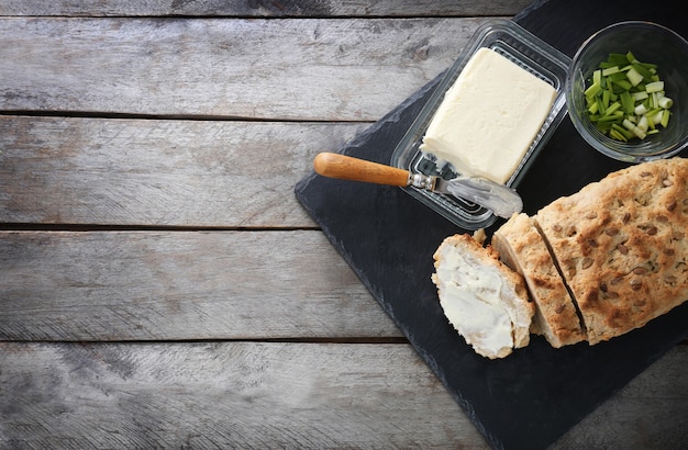 Geschnittener Laib Bierbrot mit Butter auf Schieferplatte