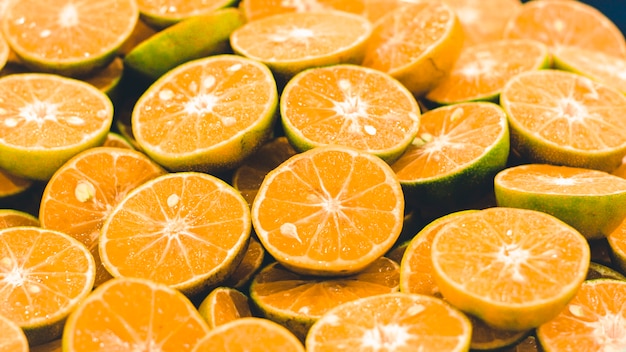 Geschnittener orangefarbener Hintergrund. Bunte orange Zitrusfruchtscheiben. Halbe Orangenfrucht, frisch und saftig. gesunde Ernährung und Vitamin C