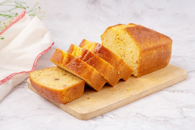 Geschnittener Pfundkuchen mit Zitronenglasur auf einem Schneidebrett.