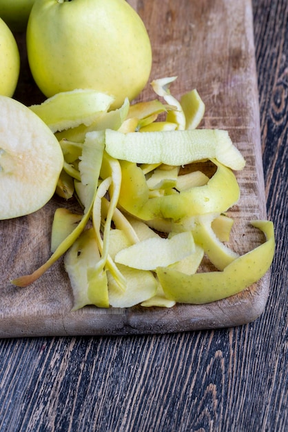 Geschnittener und geschälter grüner Apfel auf einem Holzbrett