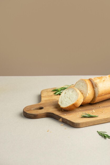 Geschnittenes Baguette mit Kräutern auf beigem Hintergrund