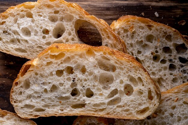 Geschnittenes Brot auf einem Brett. Auf einem Holztisch. Ansicht von oben.