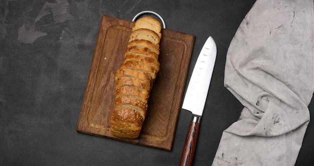 Geschnittenes Brot auf einem schwarzen Tisch, Blick von oben