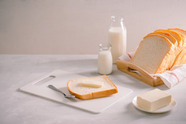 Geschnittenes Brot backen und Butter auf Holztablett. Einfaches Frühstück