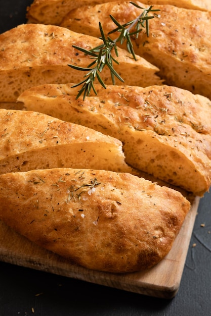 Geschnittenes Brot Ciabatta und Rosmarin auf Holzbrett