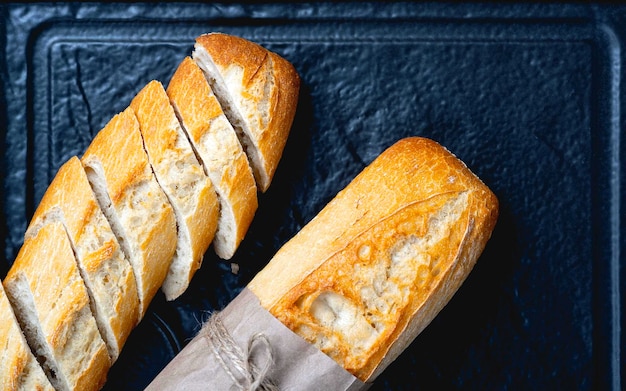 Geschnittenes Brot über dunklem Steintisch Ansicht von oben mit Kopierbereich