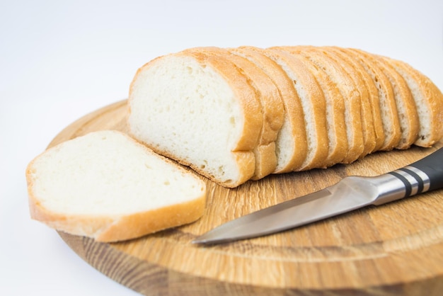 Geschnittenes Brot und ein Messer auf weißem Hintergrund Weißbrotscheiben Baton auf weißem Hintergrund