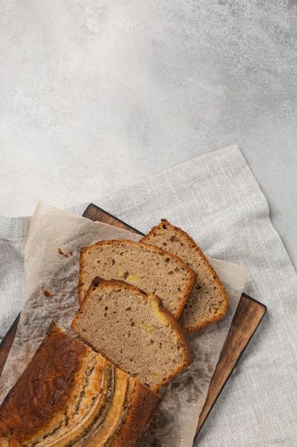 Geschnittenes fertiges bananenbrot auf einem hellen hintergrund draufsicht