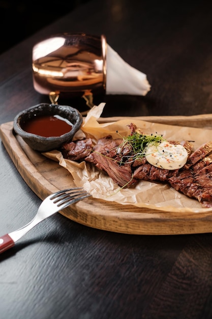 Geschnittenes Fleisch auf einem Holzbrett mit Saucen-Seitenansicht