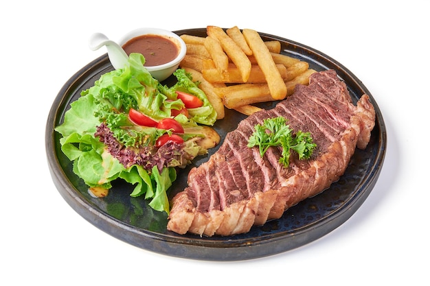 Foto geschnittenes, gegrilltes picanha-steak, serviert mit gebratenen pommes frites, frischen salat-tomaten und tauchsauce