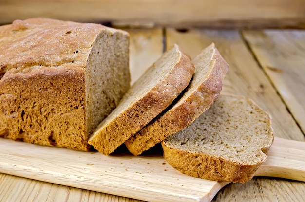 Geschnittenes hausgemachtes Roggenbrot auf Holzbretthintergrund