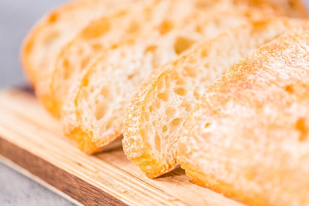 Geschnittenes Laib frisch gebackenes Ciabatta-Brot auf grauem Tisch.