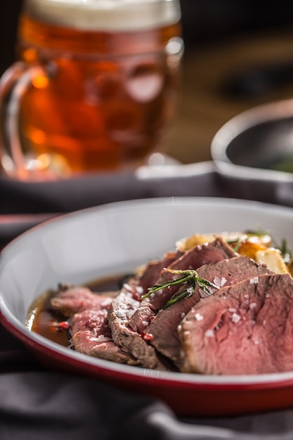 Geschnittenes Rinderfilet gebratene Steakkartoffeln Rosmarin und Fassbier.