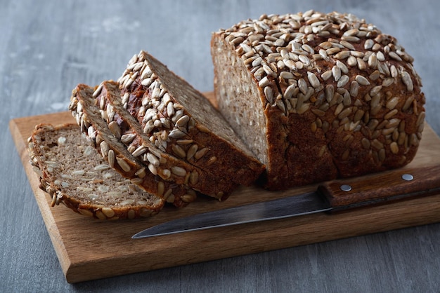 Geschnittenes Roggenbrot auf Schneidebrett Vollkorn-Roggenbrot mit Samen