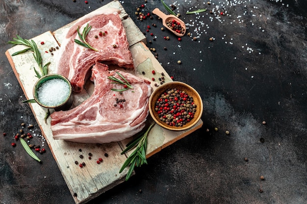 Geschnittenes rohes Schweinefleisch mit Rosmarin Bio-Schweinefleisch-Chop-Set-Banner-Menü-Rezeptplatz für Text-Draufsicht