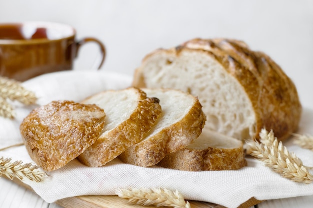 Geschnittenes rundes Weizenbrot an Bord auf dem selektiven Fokus des Tisches