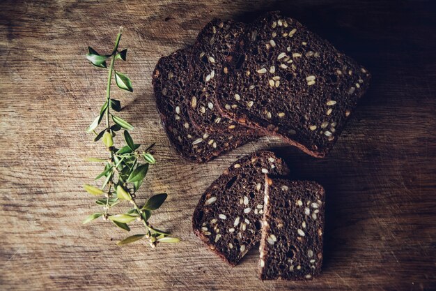 geschnittenes Schwarzbrot am Schneidebrett auf dem Holztisch