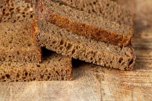 Geschnittenes Stück schwarzes Roggenbrot auf einem Brett