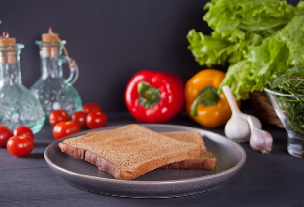 Geschnittenes Toastbrot auf Schwarzblech mit Gemüse