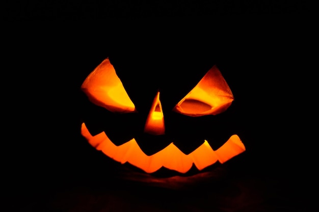 Geschnitzte Halloween-Kürbis-Jackolantern leuchtet in einer Dunkelheit