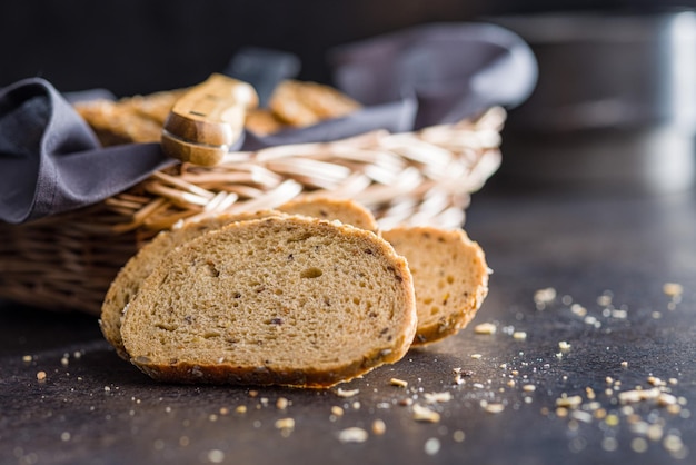 Geschnitztes Vollkornbrot Geschmackvolles Vollkerngebäck mit Samen auf dem schwarzen Tisch