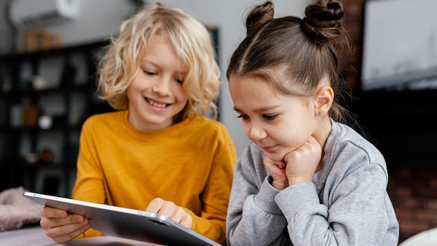 Geschwister auf der Couch mit Tablette