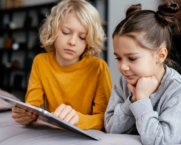 Geschwister auf der Couch mit Tablette