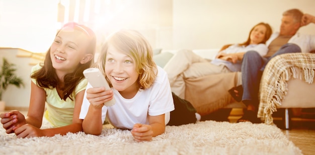 Geschwister, die auf dem Boden liegen und fernsehen