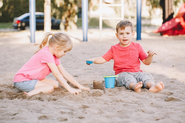 Foto geschwister, die auf dem sand spielen